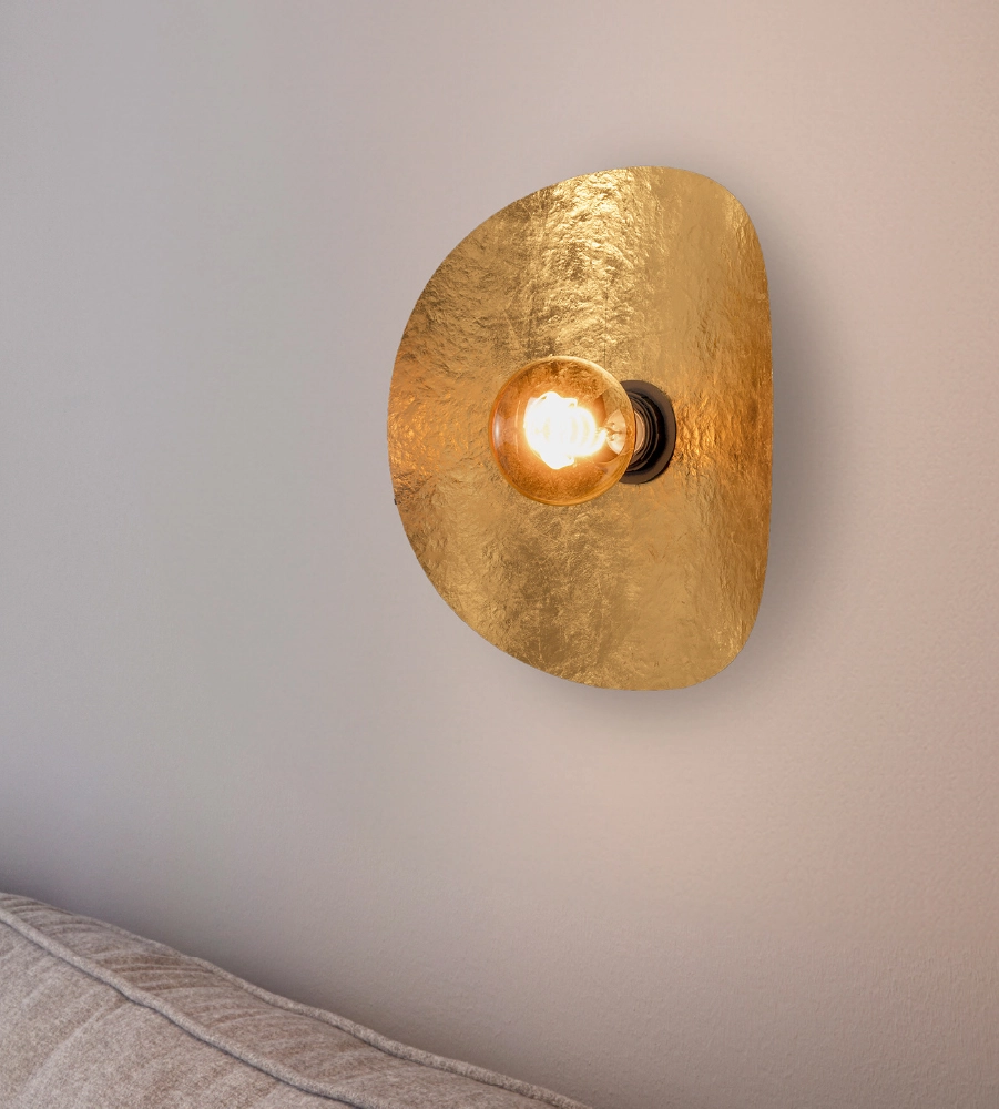 Gouden wandlamp op witte muur
