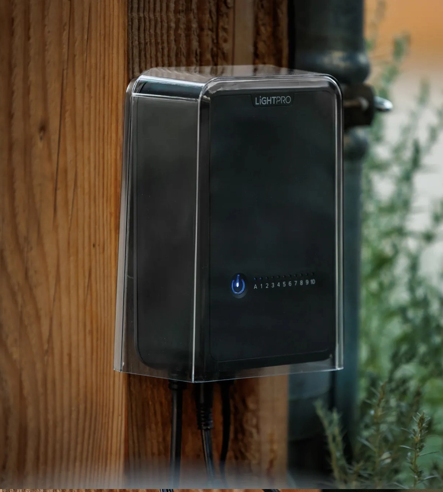 Lightpro transormator met afdekkap gemonteerd tegen houten paal